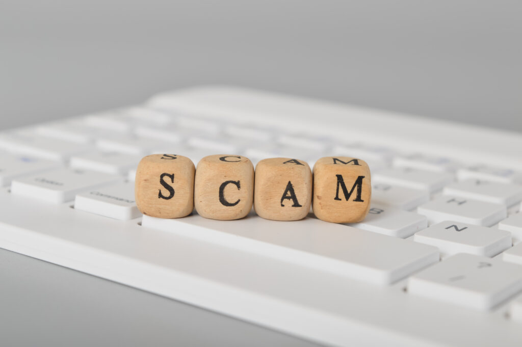 Bitcoin Scam Recovery: Computer keyboard and wooden cube with text SCAM