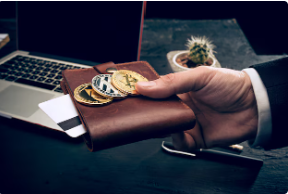 a hand holding a wallet with afew coins on top