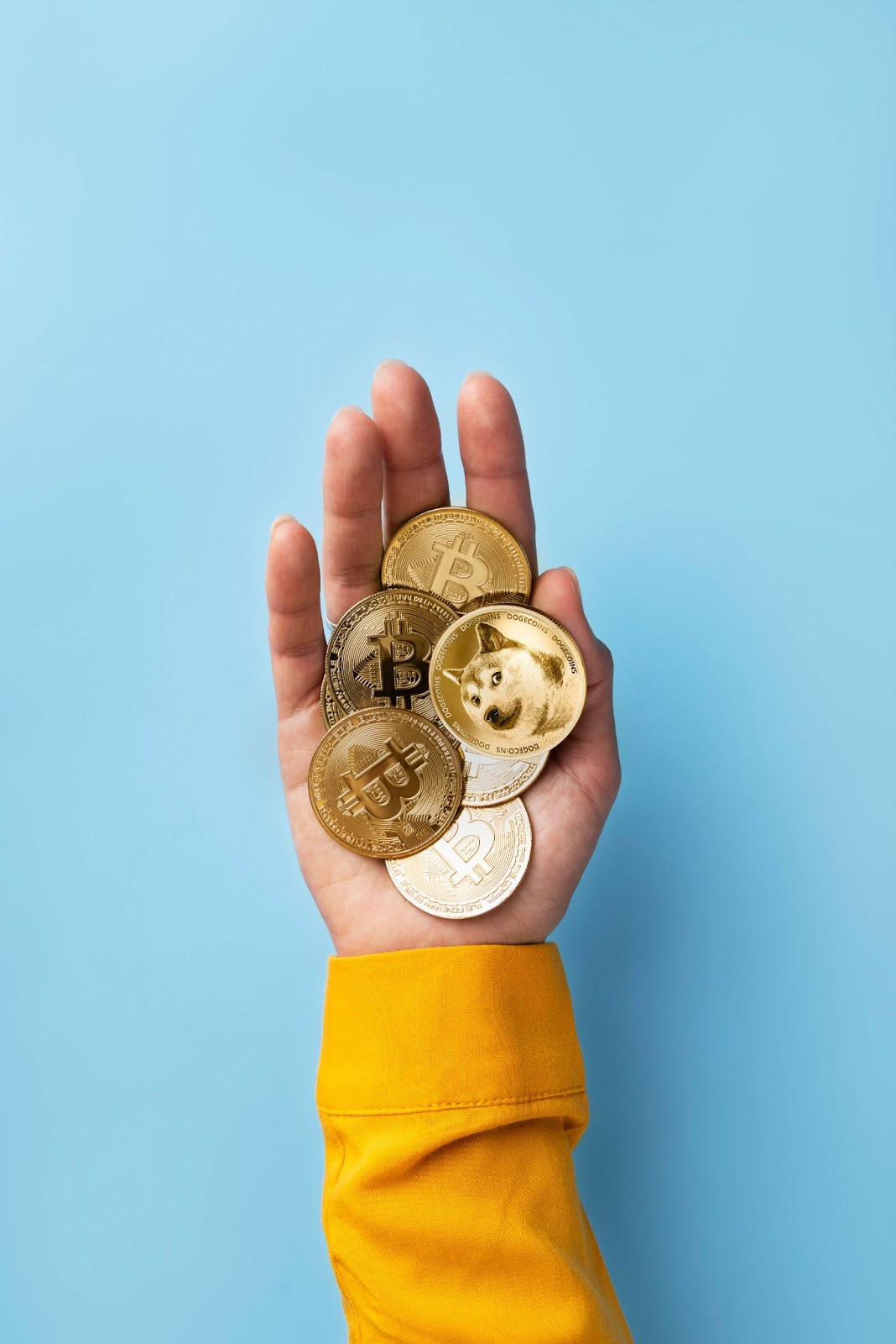  Hand holding different crypto tokens