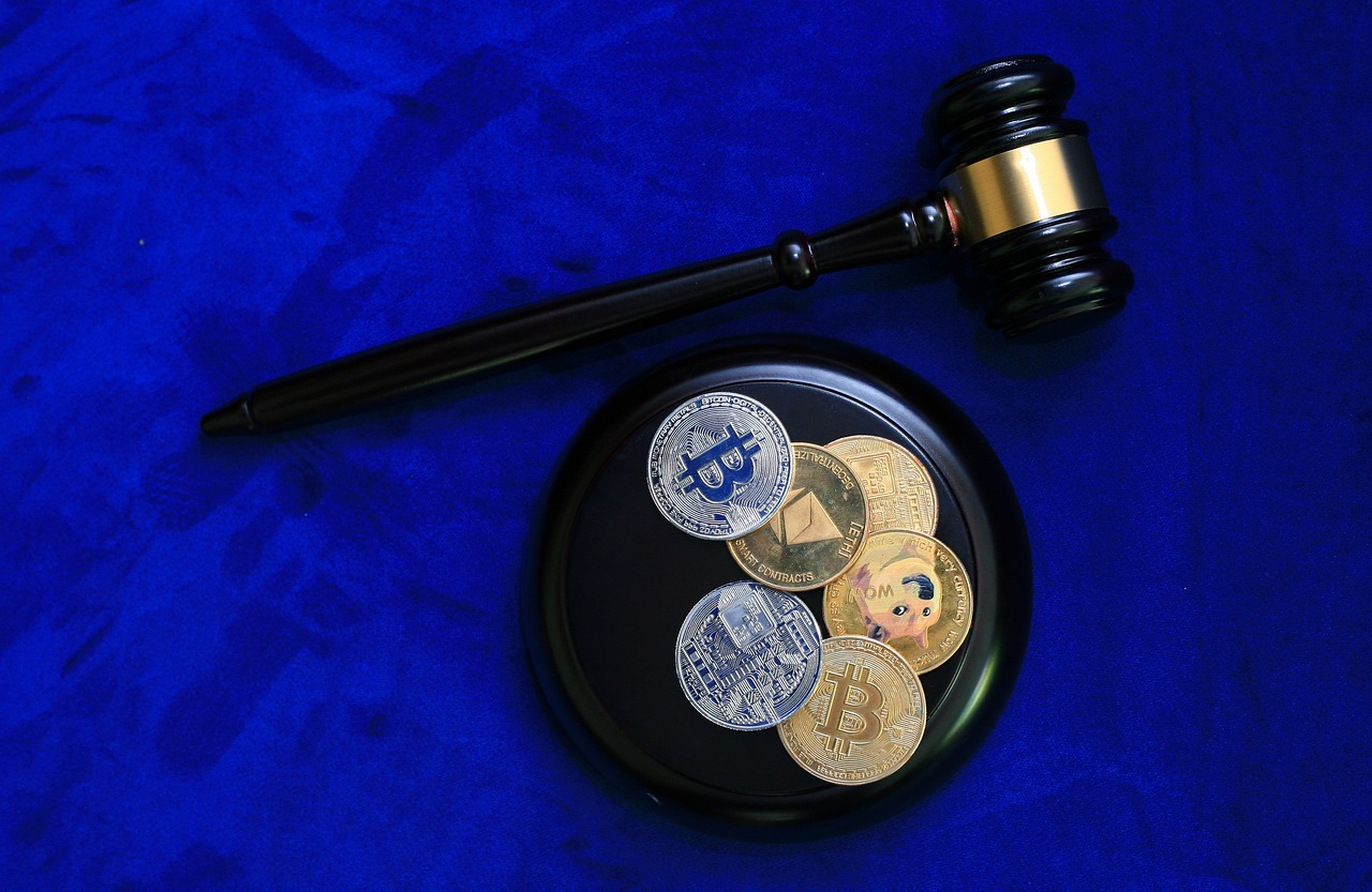 Key Regulations Governing STOs A gavel placed beside cryptocurrency coins, symbolizing the legal regulation of cryptocurrencies.