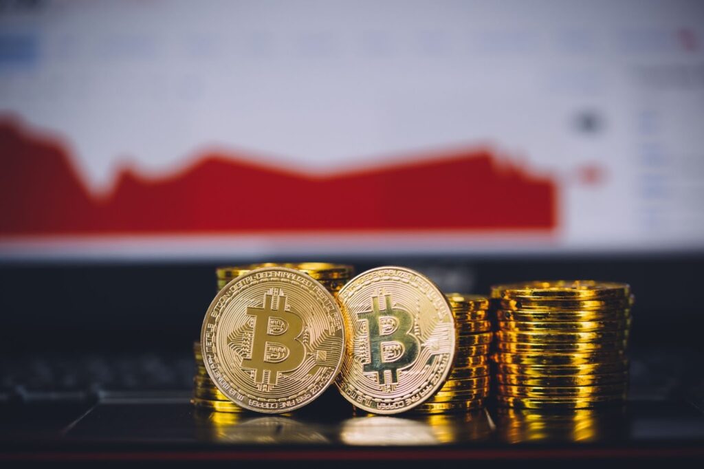 Bitcoin-Münzen stapeln sich und Zwei-Bit-Münzen liegen vorne, während der Markt abstürzt und rot wird.