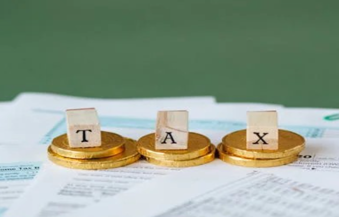 Gold coins on top of documents with inscriptions of TAX