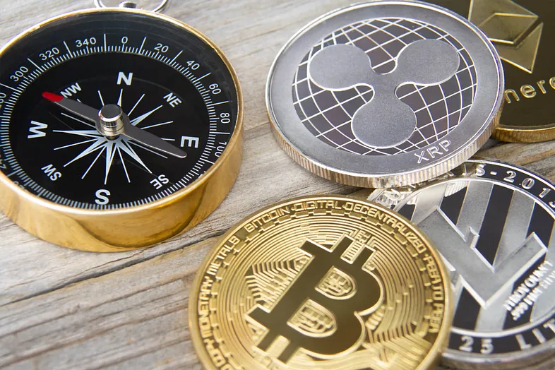 A compass next to cryptocurrencies