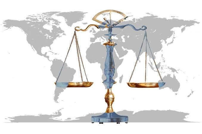 Scales of Justice in front of the world map