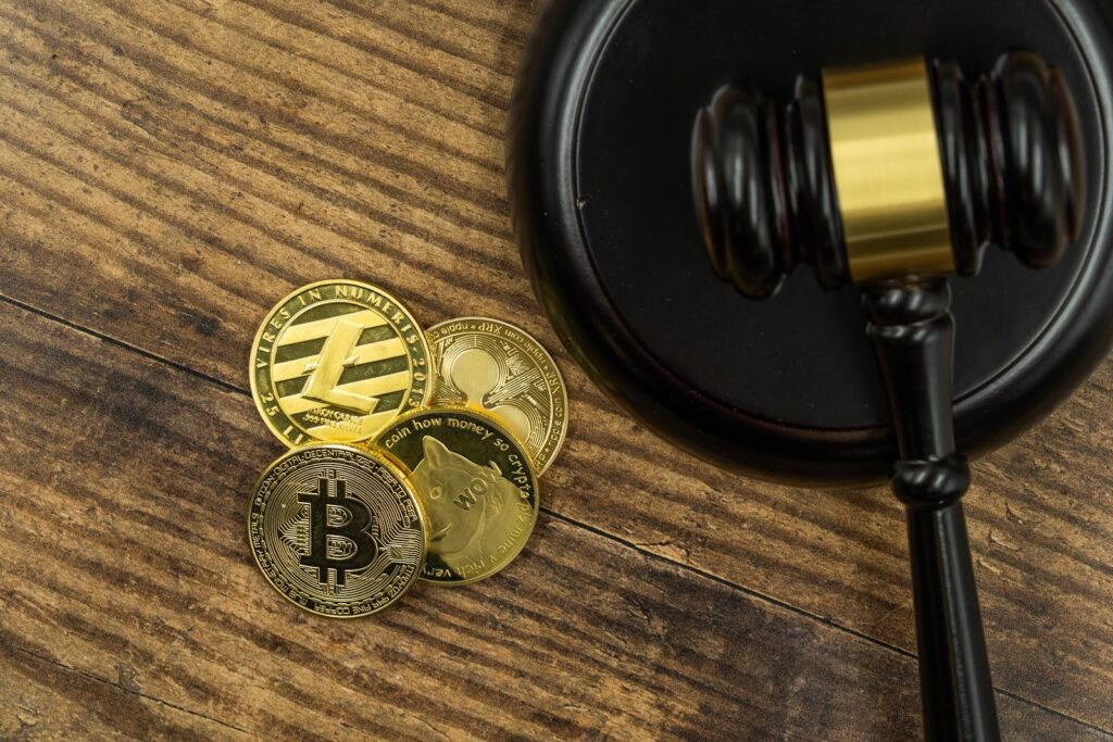 Bitcoin and notable altcoins next to an anvil.