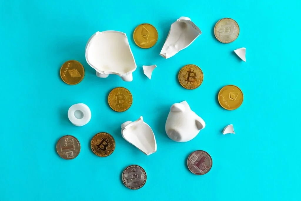 Cryptocurrency coins and broken piggy coin bank, savings and home finances concept