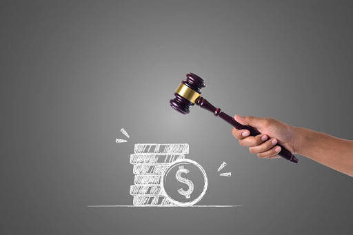 Hands holding a hammer with white coins pile