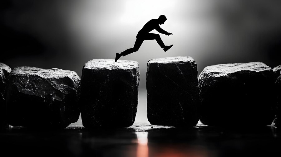 Silhouette jumping across rocks