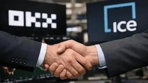 Close-up of a handshake between two business executives in front of OKX and Intercontinental Exchange (ICE) logos.