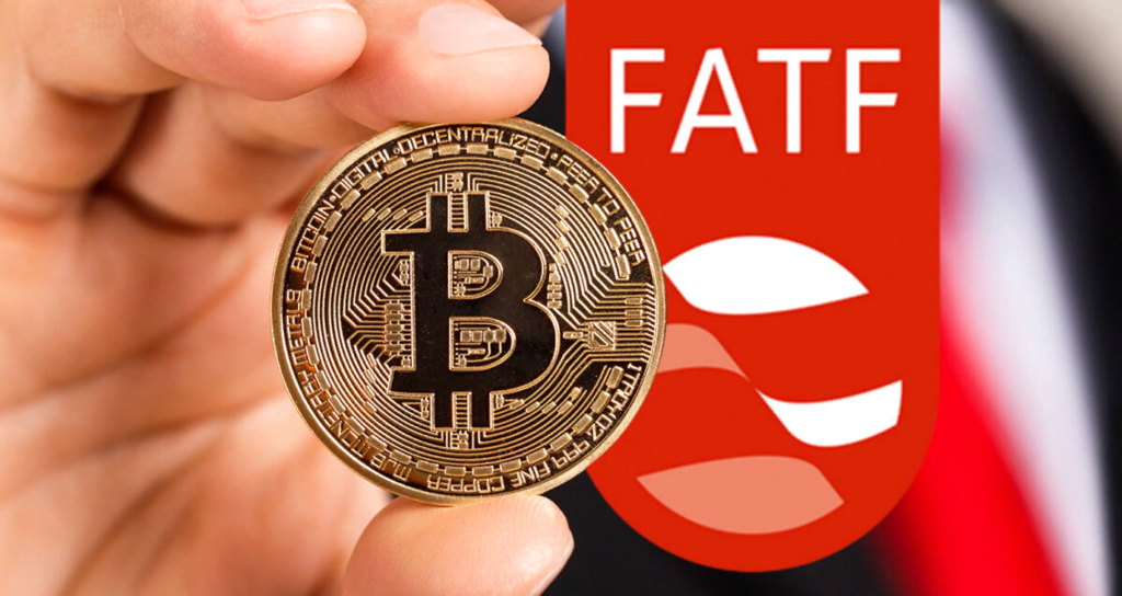 A hand holding a gold Bitcoin coin in front of the Financial Action Task Force (FATF) logo on a red background.