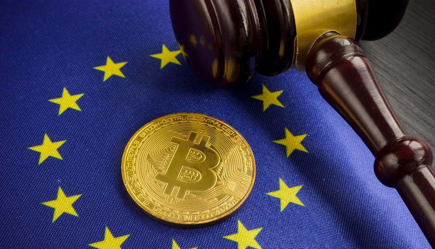 Bitcoin coin and judge’s gavel displayed on the European Union flag, representing EU cryptocurrency regulation.