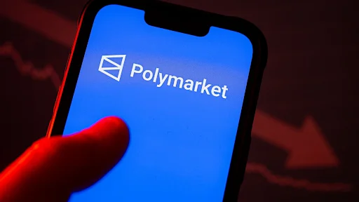 Polymarket logo displayed on a smartphone screen against a red background with a downward market chart.